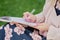 girl with pen writing on notebook on grass outside.