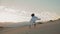 Girl performer dancing fabric fluttering wind at sunset sky in sand desert.