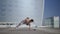 Girl performing yoga at street. Woman doing extended side angle pose at street