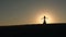 Girl performs a beautiful belly dance against the sunset, graceful movements. Silhouette