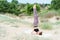 Girl performs inverted yoga asanas outdoors, candle pose