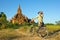 Girl photographer on a bicycle takes a picture of the temple in