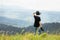 A girl photographer stands on top of a mountain and thinks about her best shots. Below a beautiful view and horizon