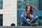 A girl photographer uses a smartphone and sits on a granite para