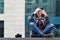 A girl photographer uses a smartphone and sits on a granite para