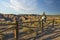 Girl photographing the desert landscape, leaning on a wooden fence