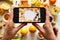 A girl photographs healthy food on a smartphone.