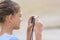 Girl photographs moments from a beach holiday on a digital camera