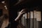 A girl picking an antique book on a shelf of a reading hall in a library with her pale hand.