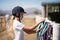 Girl picking up a horse muzzle in the ranch