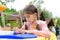 Girl with pigtails draws a picture with colored sand. child creative development concept