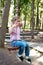 Girl with pigtails wearing pink shirt and jeans roll on a swing along a string in a park in summer