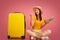 Girl with pineapple pointing at suitcase, going vacation