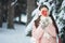 Girl in pink coat in snow Park. Girl plays in winter Park. Adorable child walking in snow winter forest