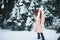 Girl in pink coat in snow Park. Girl plays in winter Park. Adorable child walking in snow winter forest