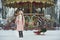 Girl in pink coat in snow Park. Girl plays in winter Park. Adorable child walking in snow winter forest
