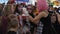 Girl with pink hair gives children sniff steam in boiling glass flask on celebration halloween