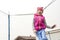 Girl in pink hats and jackets jumps on a trampoline. Street lighting. Close-up