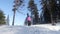 The girl in the pink jacket goes with a snowboard in the woods.