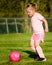 Girl in pink playing soccer on field