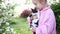 Girl in pink shirt in garden in summer. child holds kitten in his arms outdoors.