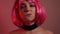 Girl with pink short hair. A model with long pink earrings and makeup. The girl in the video laughs, flirts, poses, dances, touche