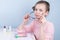 Girl in a pink sweater, sitting at the table, took off contact lenses and wears glasses to improve vision