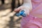 Girl in pink t-shirt is playing blue metal spinner in hands on the street, woman playing with a popular fidget spinner toy
