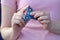 Girl in pink t-shirt is playing blue metal spinner in hands on the street, woman playing with a popular fidget spinner toy, anxiet