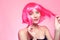 The girl in a pink wig, on a pink background, is happy, grimaces, smiles. Bright photo of a teenager, smart, party, dance. Anime