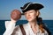 The girl-pirate looks in a jug against the sea