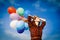 Girl in plaid dress with multicolored balloons