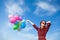 Girl in plaid dress with multicolored balloons