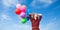 Girl in plaid dress with multicolored balloons