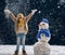 Girl plaing with a snowman