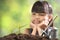 A girl planting young plant on soil with a hope of good environment