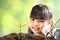 A girl planting young plant on soil with a hope of good environment