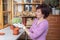 Girl plants cactus in pot on the veranda of the house. Woman holding in the hands in glove big cactus Gymnocalycium. Side view