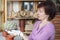 Girl plants cactus in pot. Woman looks at plant. Woman holding in the hands in glove big cactus Gymnocalycium. Side view