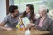 Girl playing with alphabet blocks by father and grandmother at table in house