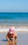 Girl Playing on a Beach on Pink Swimming Costume and Hat