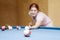 Girl playing billiards.