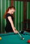 Girl playing billiards in club