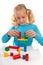 Girl is playing with colorful wooden blocks