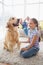 Girl playing with dog while parents relaxing at home