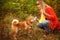 Girl playing with a dog Shiba Inu in autumn park.