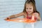 Girl playing hand made toy called slime. Children play with big orange slime