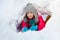 Girl is playing outside in tunnel she dug of snow