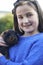 Girl Playing With Pet Guinea Pig Outdoors In Garden