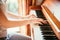 Girl is playing piano at home, high angle view, blurry background